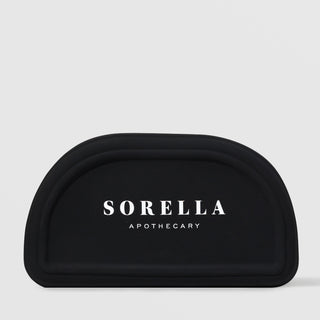 Sorella Apothecary fan mask brush with white bristles and white handle on a light gray background