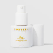 Sorella Apothecary Tinted Dew Drops Broad Spectrum SPF 50 1 fl oz in a white pump bottle without cap on a light gray background