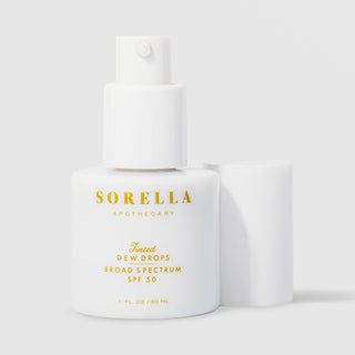 Sorella Apothecary Tinted Dew Drops Broad Spectrum SPF 50 1 fl oz in a white pump bottle without cap on a light gray background