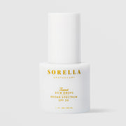 Sorella Apothecary Tinted Dew Drops Broad Spectrum SPF 50 1 fl oz in a white pump bottle with cap on a light gray background