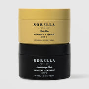Sorella Apothecary Vitamin C + Ferulic Peel Pads two-step set with gold Step 1 jar stacked on black Step 2 Mineral Treatment jar on a light gray background