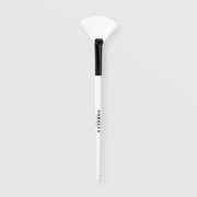 Sorella Apothecary fan mask brush with white bristles and white handle on a light gray background