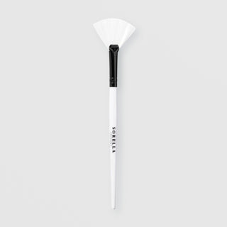 Sorella Apothecary fan mask brush with white bristles and white handle on a light gray background