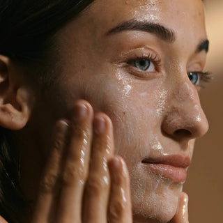 Woman massaging Sorella Apothecary Apricot and Mango Cleansing Milk onto her face with a dewy, glowing complexion