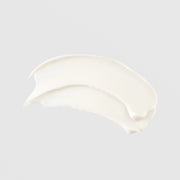 TIZO AM Replenish SPF 40 untinted sunscreen crescent-shaped cream swatch showing smooth opaque white texture on grey background