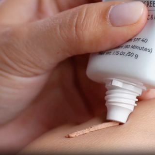 TiZO3 Facial Mineral Sunscreen SPF 40 Tinted being squeezed onto skin showing light beige tinted cream texture