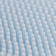 Close-up of the Art of Skin Care blue silicone face scrubby showing rows of soft rounded bristles designed for gentle facial cleansing and exfoliation.
