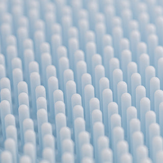 Close-up of the Art of Skin Care blue silicone face scrubby showing rows of soft rounded bristles designed for gentle facial cleansing and exfoliation.