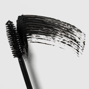 Colorescience Total Lash Mascara wand close-up showing black bristle brush with bold black formula swatch on grey background