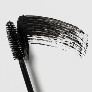 Colorescience Total Lash Mascara wand close-up showing black bristle brush with bold black formula swatch on grey background
