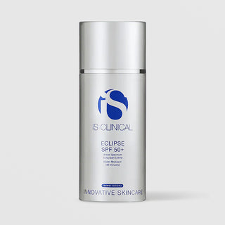 iS Clinical Eclipse SPF 50+ broad spectrum sunscreen crème in a silver airless pump bottle, cap removed, on a light gray background