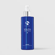 iS Clinical Youth Body Serum in a cobalt blue bottle with silver pump on a light gray background
