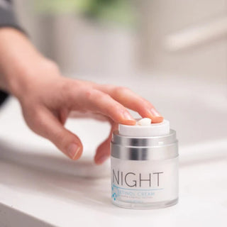 Hand opening FactorFive Night Retinol Cream jar on bathroom counter