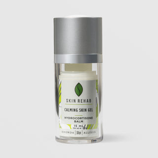 Rhonda Allison Skin Rehab Calming Skin Gel Hydrocortisone Balm in a 15mL clear airless pump bottle with silver cap and green leaf logo on a light gray background