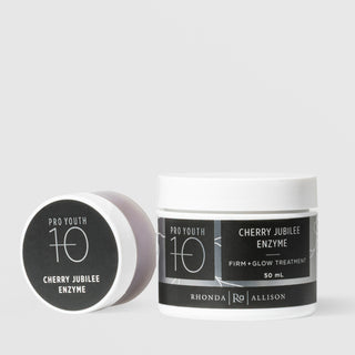 Rhonda Allison Pro Youth 10 Cherry Jubilee Enzyme Firm and Glow Treatment shown in both sizes: small travel jar leaning on its side and 50mL upright white jar with black botanical labels on a light gray background