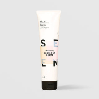 SEEN Skin-Caring Blow-Out Creme (5 fl oz) in a white squeeze tube with a black cap and bold SEEN lettering accented by soft peach, pink, and blue color blocks, labeled dermatologist designed and non-comedogenic, displayed against a light gray background.