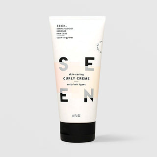 SEEN Skin-Caring Curly Creme (6 fl oz) in a white squeeze tube with a black cap and bold SEEN lettering accented by soft peach color blocks, labeled dermatologist designed and formulated for curly hair types, displayed against a light gray background.