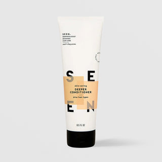 SEEN Skin-Caring Deeper Conditioner (8.5 fl oz) in a white squeeze tube with a black cap and bold SEEN lettering accented by warm tan color blocks, labeled dermatologist designed and formulated for drier hair types, displayed against a light gray background.
