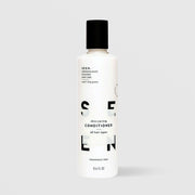 SEEN Fragrance Free Skin-Caring Conditioner (8.6 fl oz) in a white bottle with black flip cap and bold black SEEN lettering, labeled dermatologist designed, non-comedogenic, and suitable for all hair types, displayed against a light gray background.