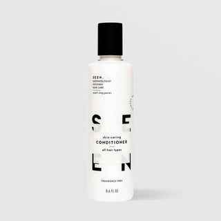 SEEN Fragrance Free Skin-Caring Conditioner (8.6 fl oz) in a white bottle with black flip cap and bold black SEEN lettering, labeled dermatologist designed, non-comedogenic, and suitable for all hair types, displayed against a light gray background.