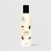 SEEN Skin-Caring Shampoo (8.6 fl oz) in a white bottle with black flip cap and bold black SEEN lettering, labeled dermatologist designed, non-comedogenic, and suitable for all hair types, displayed against a light gray background.