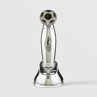 TOV Time Master Pro silver handheld LED facial device with multi-LED treatment head and charging base, featuring mode selector and LED selection controls